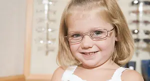 Smiling young girl wearing eyeglasses in an optical shop